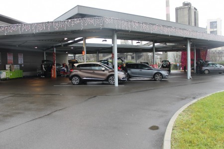 Après être passé par une borne qui vous a attribué un numéro de place vous vous garez et vous ouvrez votre coffre en attendant que le préparateur vienne vous livrer.